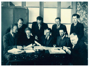 En 1946, Irène et Frédéric Joliot Curie entourés des pionniers du CEA : P. Auger, F. Perrin, L. Kowarski et en haut, B. Goldchmidt, P. Bicquart, L. denivelle et J. Langevin